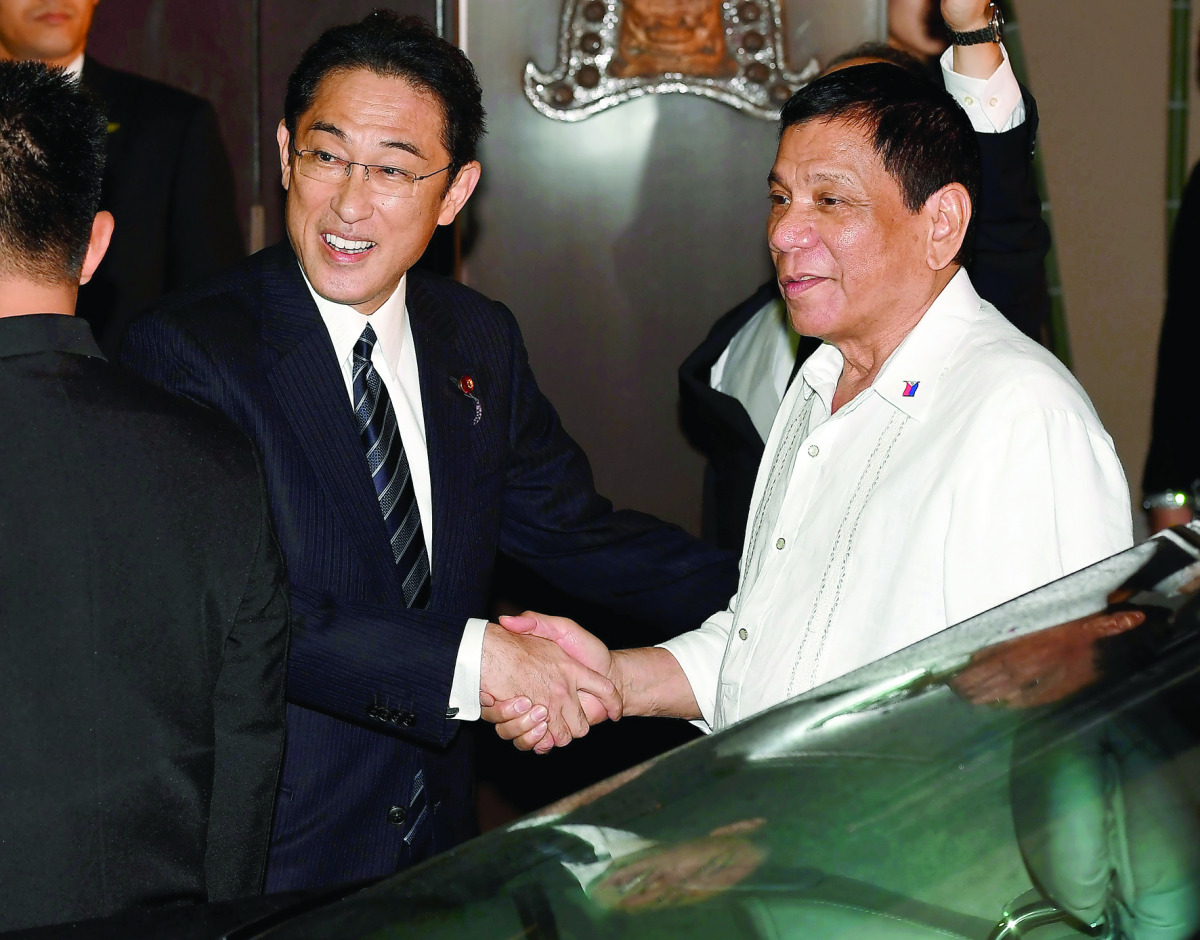 Philippines' President Rodrigo Duterte (R) is welcomed by Japanese Foreign Minister Fumio Kishida (L) prior to their dinner meeting at the entrance of a Japanese restaurant in Tokyo on October 25, 2016. Duterte is here on a three day visit. (AFP / TOSHIFU