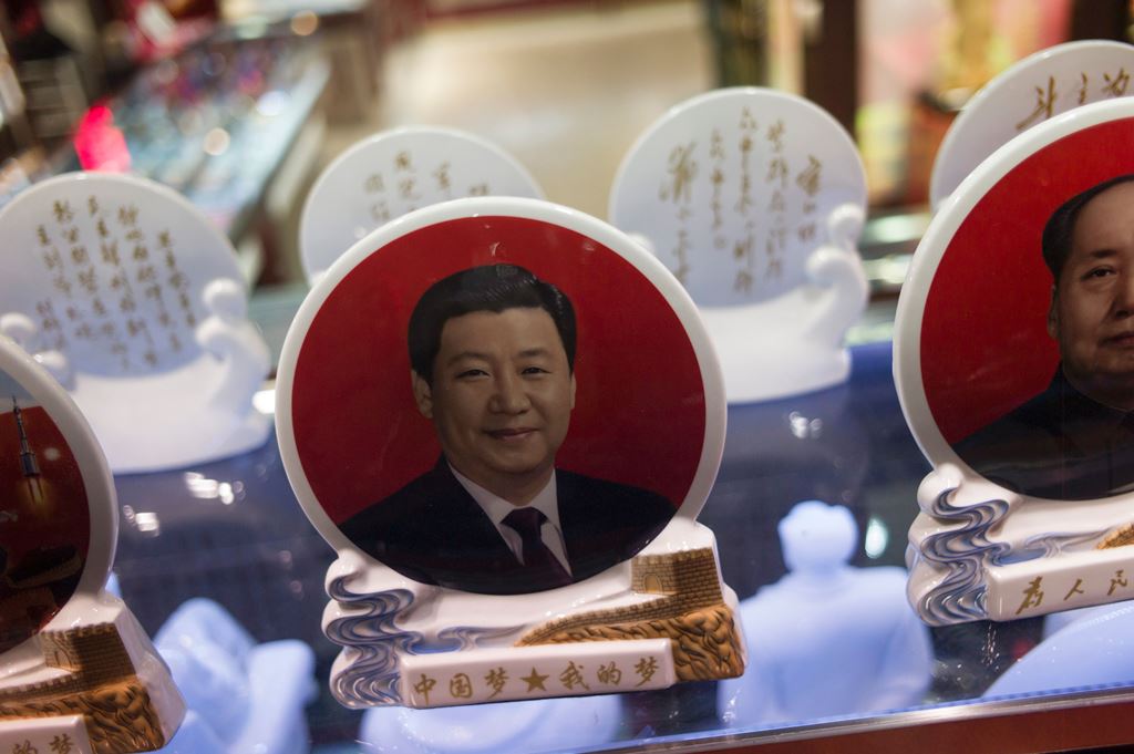 Portraits of Chinese leaders like China's President Xi Jinping (L) and former Chinese Chairman Mao Zedong (R) are on display in a shop in Tiananmen Square in Beijing on October 24, 2016. AFP / FRED DUFOUR