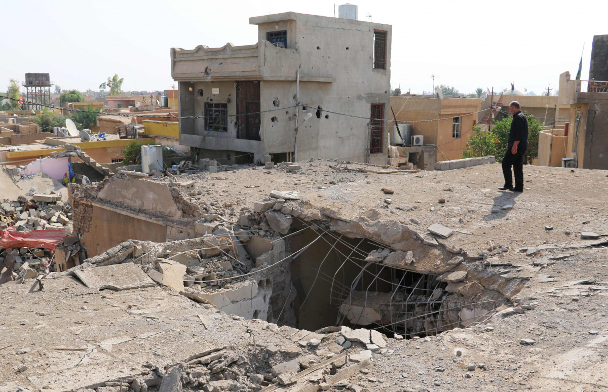 An Iraqi man stands on top of a damaged building on October 27, 2016, a few days after an air strike hit a Shiite place of worship in the Iraqi town of Daquq, south of Kirkuk. Residents of Daquq, where the air strike on a Shiite place of worship killed 15