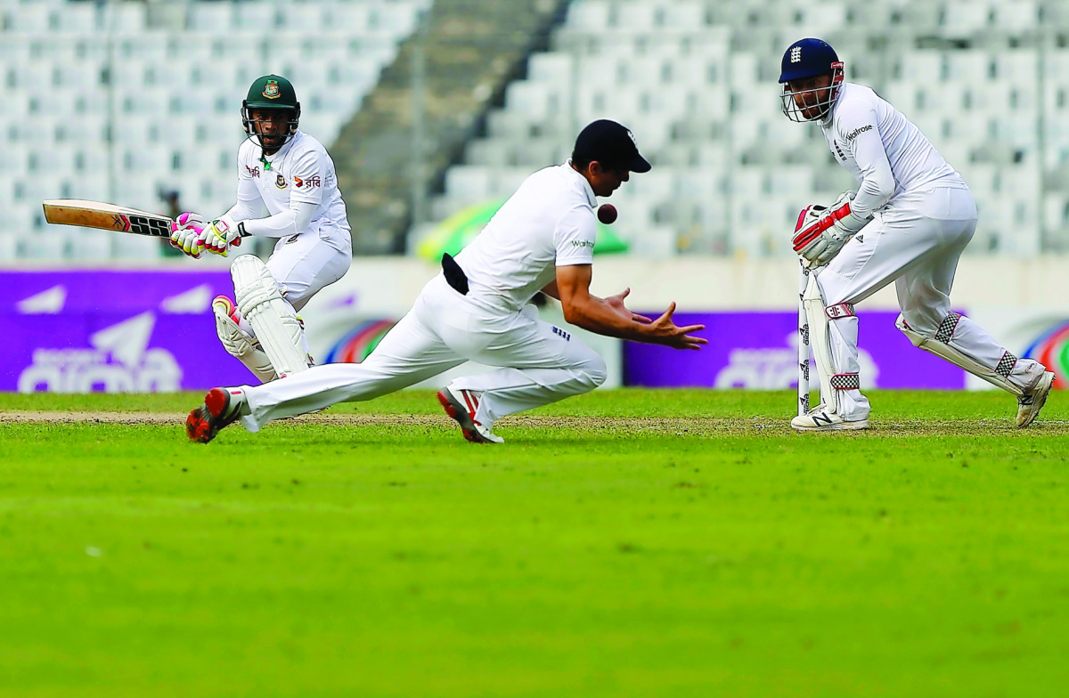 England’s captain Alastair Cook takes a catch to dismiss Bangaldesh’s captain Mohammad Rahim (left) during their second Test match which started at Sher-e-Bangla Stadium in Dhaka, Bangladesh yesterday.