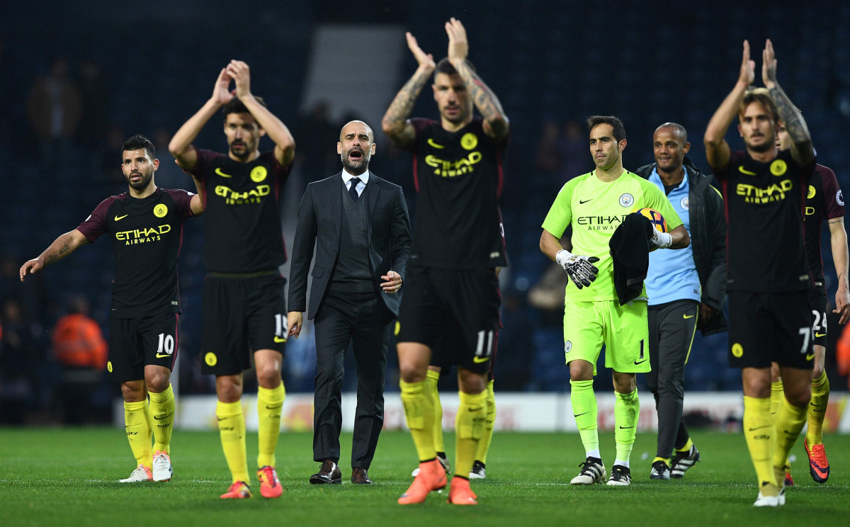 Manchester City's Spanish manager Pep Guardiola (C) celebrates on the pitch with his players after the English Premier League football match between West Bromwich Albion and Manchester City at The Hawthorns stadium in West Bromwich, central England, on Oc