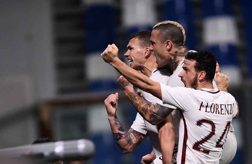 TOPSHOT - Roma's forward from Bosnia-Herzegovina Edin Dzeko (L) celebrates with Roma's midfielder from Belgium Radja Nainggolan and Roma's midfielder from Italy Alessandro Florenzi (R) after scoring a penalty during the Italian Serie A football match Sass