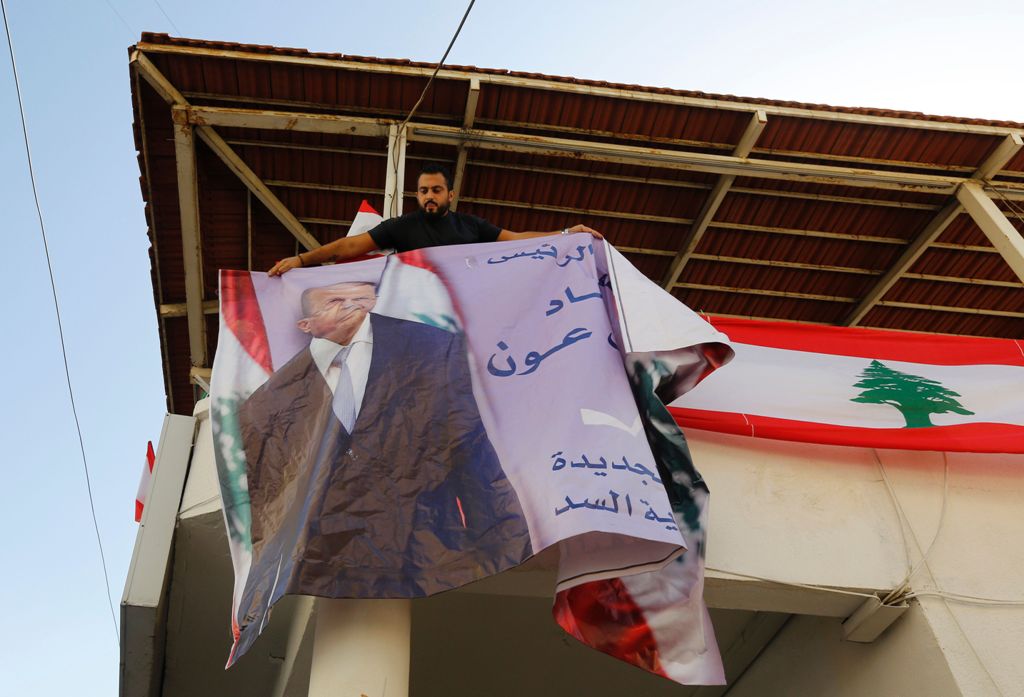 A supporter of Lebanese presidential candidate Michel Aoun puts up a portrait of him ahead of a parliament session expected to elect the ex-general as president and end a political stalemate of more than two years, as they gather in Jdeidah, on the northe