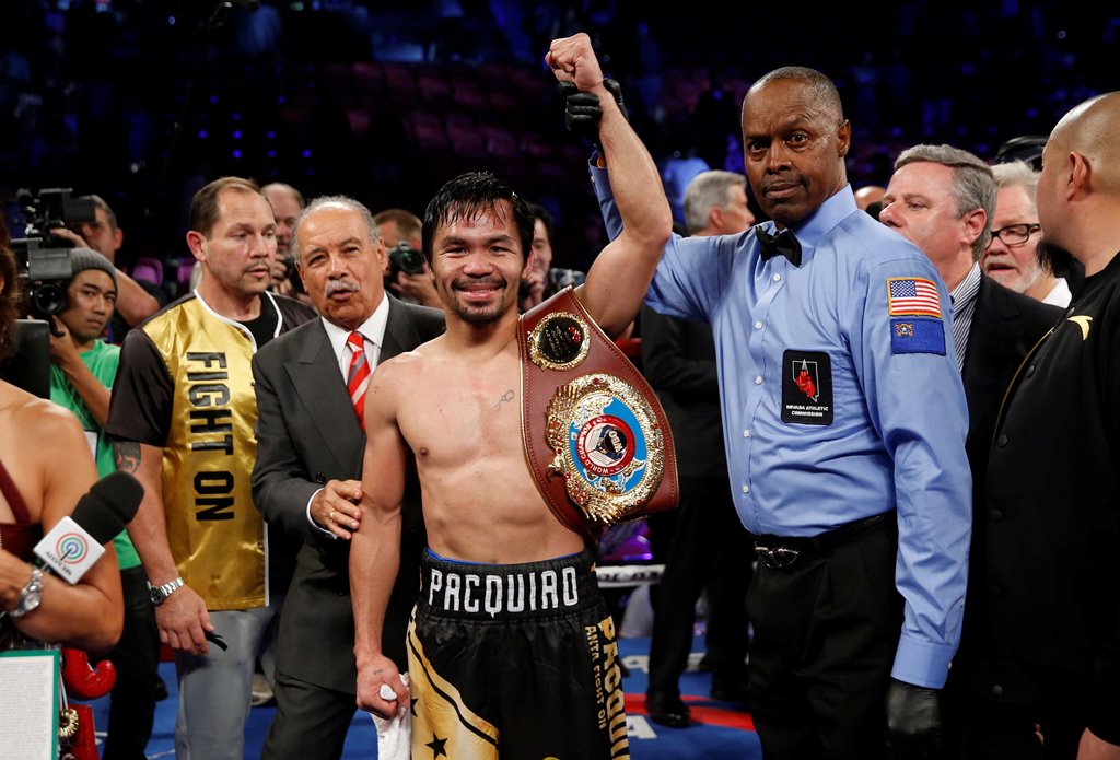 Manny Pacquiao celebrates his victory over WBO welterweight champion Jessie Vargas following their title fight at the Thomas & Mack Center in Las Vegas, Nevada, U.S., November 5, 2016. Referee Kenny Bayless is at right. Reuters/Las Vegas Sun/Steve Marcus