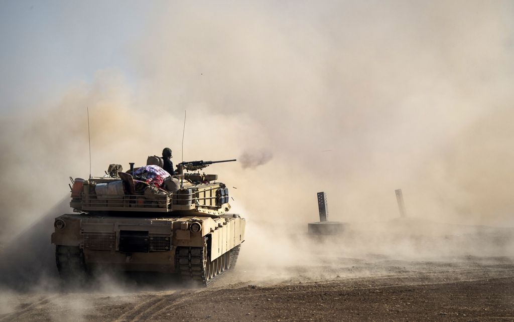 Dust rises as a tank from the Iraqi army's 9th armoured division fires at a suspect car approaching their position in the area of Ali Rash, adjacent to the eastern Al-Intissar neighbourhood of Mosul, on November 6, 2016, during a military operation to ret