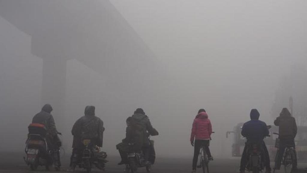 Residents wait for the traffic at an intersection amid heavy smog in Shijiazhuang, Hebei province, China. (Reuters).
