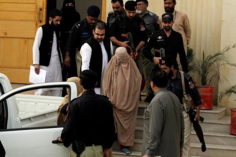 Policemen escort Sharbat Gula (C), the green-eyed Afghan woman who became a symbol of her country's wars 30 years ago when her photo as a girl appeared on the cover of National Geographic magazine, as she leaves after appearing before a court in Peshawar,