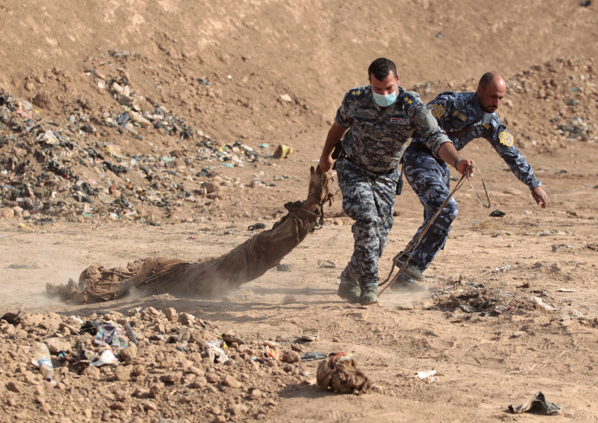 Iraqi forces pull a body out from a mass grave they discovered in the Hamam al-Alil area on November 7, 2016 after they recaptured the area from Islamic State (IS) group jihadists during the ongoing operation to retake Mosul, the last IS-held Iraqi city. 