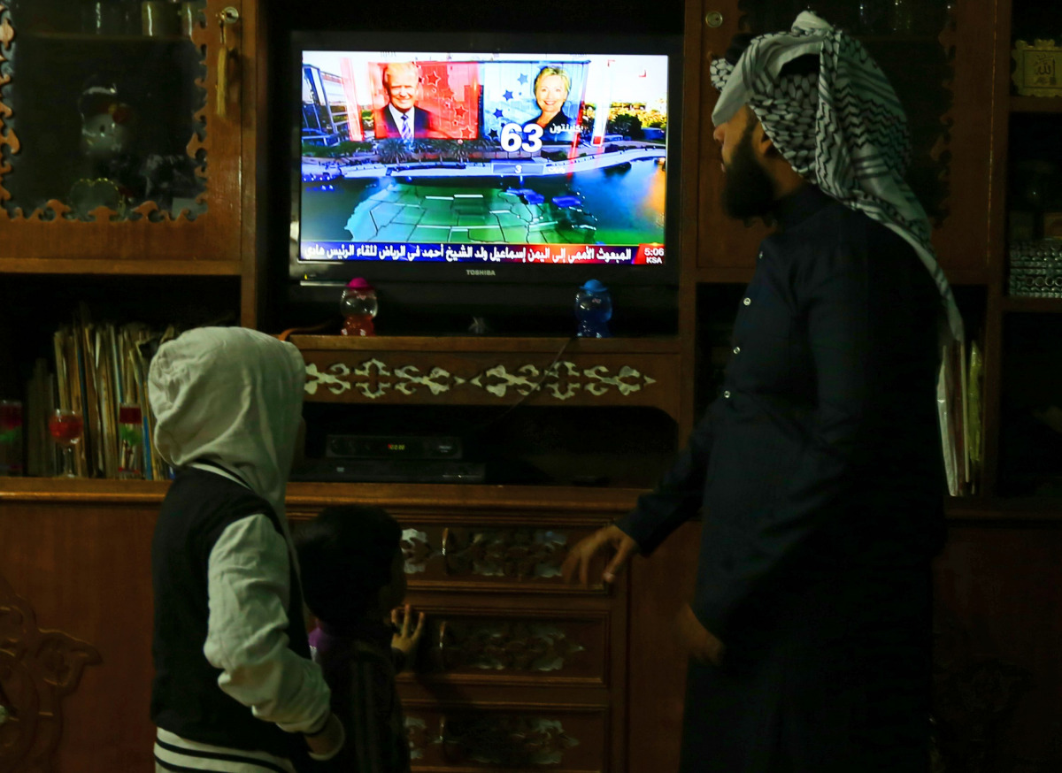 An Iraqi family follows the US presidential elections on television at their home in Baghdad on November 8, 2016. AFP / SABAH ARAR