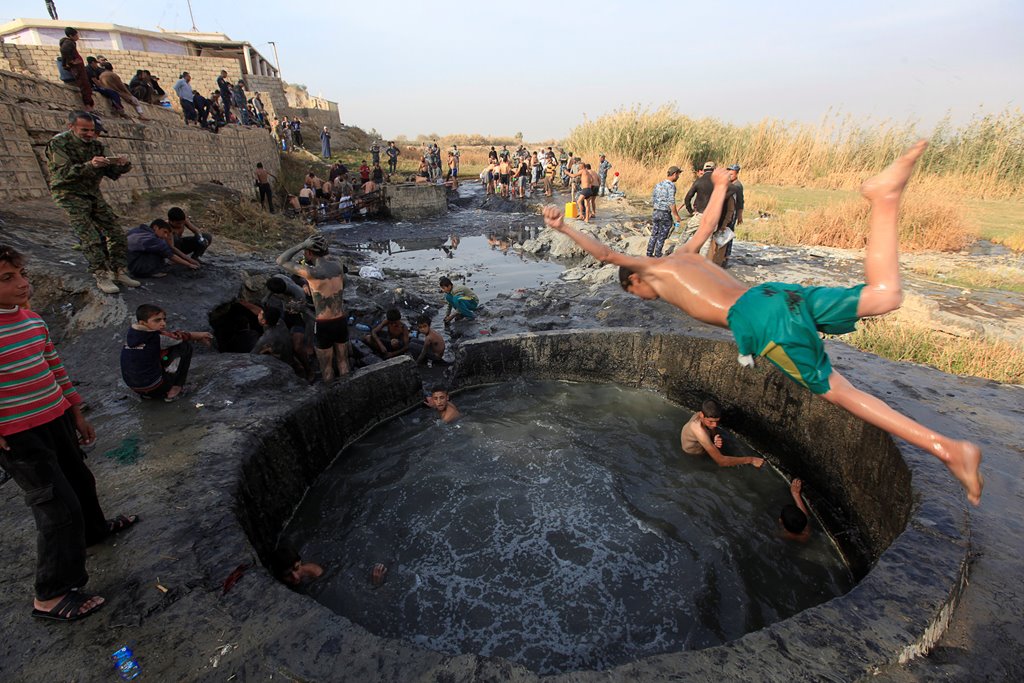 People with Iraqi security forces swim in a sulphur pond in Hammam al-Ali, south of Mosul, Iraq November 9, 2016. REUTERS/Alaa Al-Marjani
