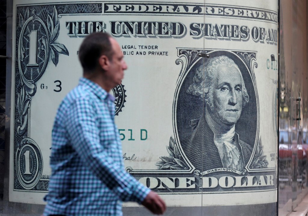 A man walks past a currency exchange bureau advertisement showing an image of the U.S. dollar in Cairo, Egypt, November 11, 2016. REUTERS/Mohamed Abd El Ghany
