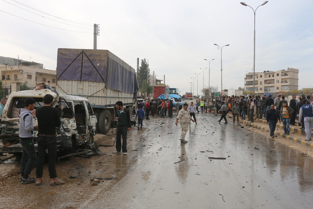 ALEPPO, SYRIA - NOVEMBER 13: Syrian people walk near a wreckage of car after car bomb attack at the Azez district of Aleppo, Syria on November 13, 2016. ( Mamun Ebu Ömer - Anadolu Agency )