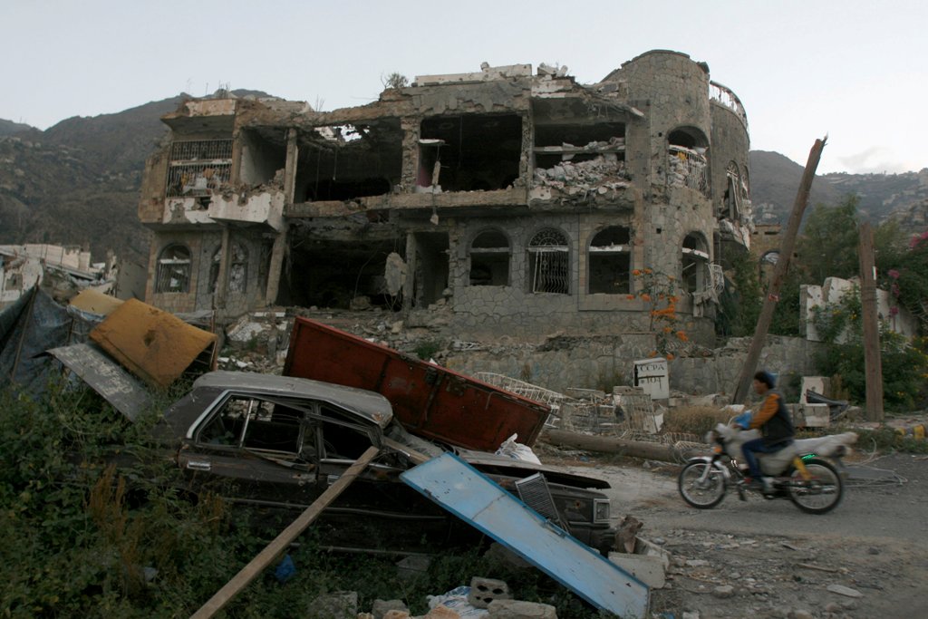 A man rides a motorbike past a house destroyed during recent battles between Houthi fighters and pro-government fighters in the southwestern city of Taiz, Yemen November 18, 2016. REUTERS/Anees Mahyoub
