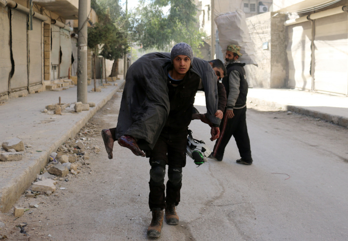 A Syrian civil defence volunteer, known as the White Helmets, carries an injured man on November 19, 2016 following a reported air strike on Aleppo's rebel-held neighbourhood of Bab al-Nayrab. Intense government air strikes and artillery fire killed at le