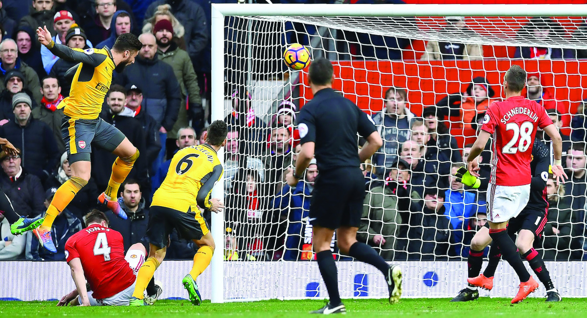 Arsenal's French striker Olivier Giroud (L) scores his team's first goal during the English Premier League football match between Manchester United and Arsenal at Old Trafford in Manchester, north west England, on November 19, 2016. AFP / Paul ELLIS