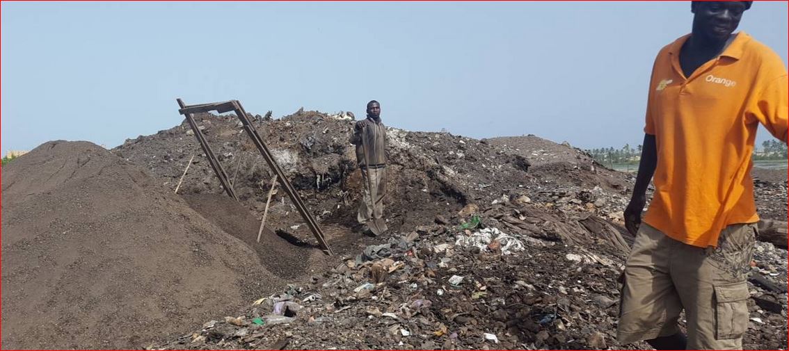 Bokk Diom manager Pape Mar Diallo stands in front of recycler Marcel Gomis in Mbeubeuss, Senegal, Oct. 4, 2016.