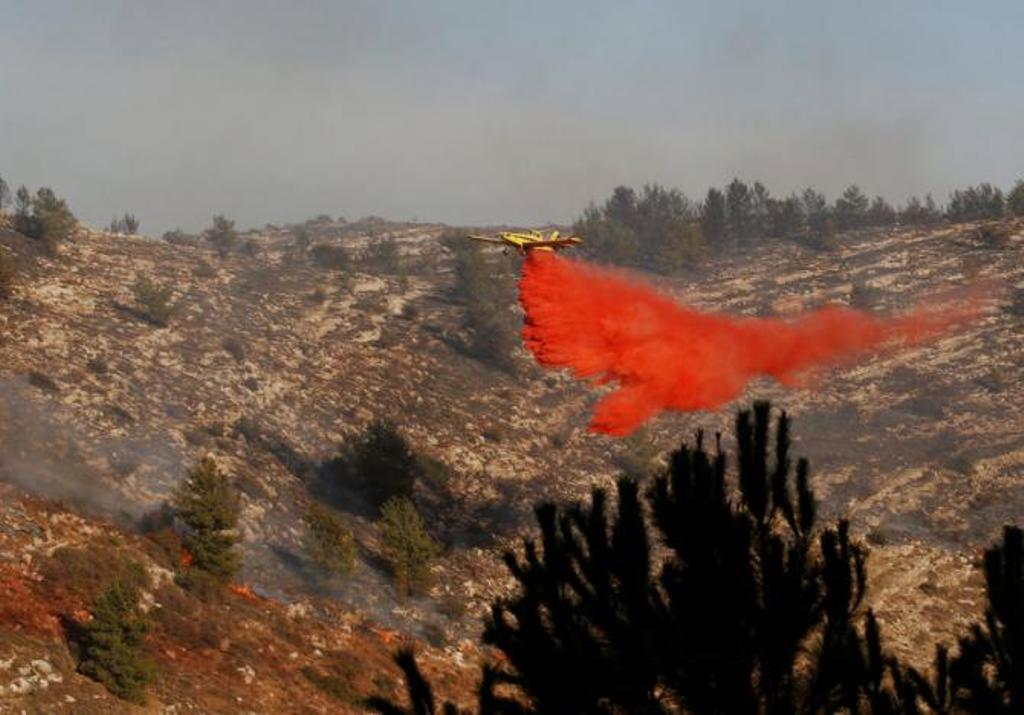 A firefighting plane drops fire retardant during a wildfire, near the communal settlement of Nataf, close to Jerusalem November 23, 2016. REUTERS/Ronen Zvulun
