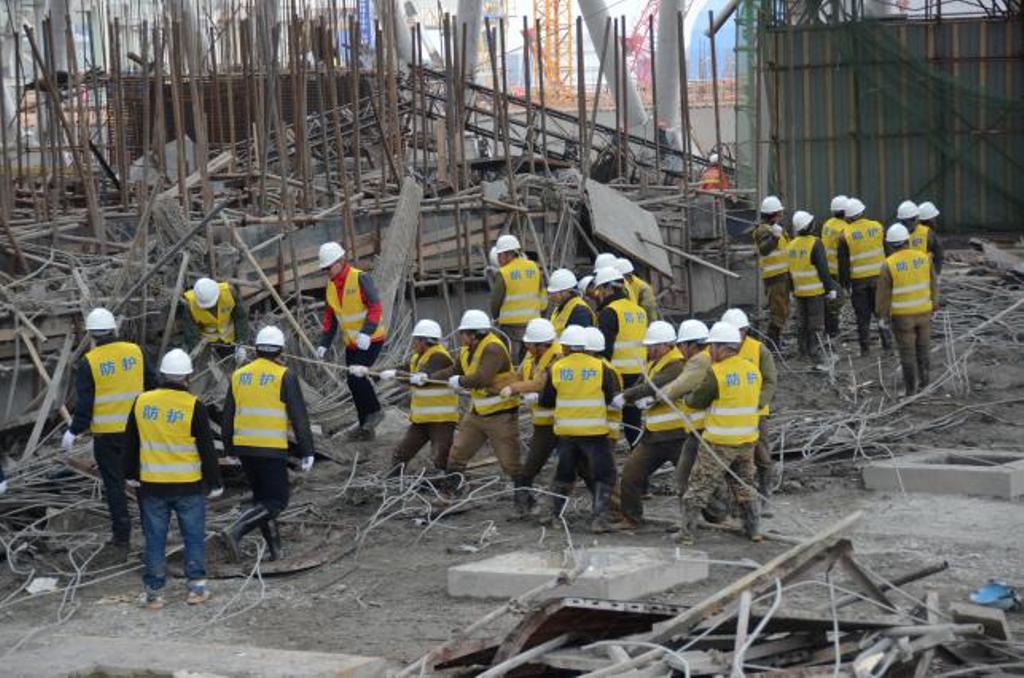 Rescue workers search at the site where a power plant`s cooling tower under construction collapsed in Fengcheng. Photo: Reuters.