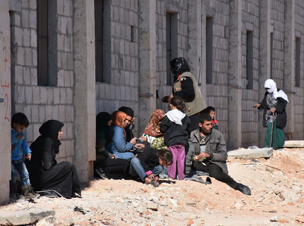 Syrian displaced families gather at a makeshit camp on November 27, 2016 in the government-held district of Jibreen in Aleppo, as civilians have fled the eastern part of the city in the past 24 hours as regime forces advance against rebel-held districts. 