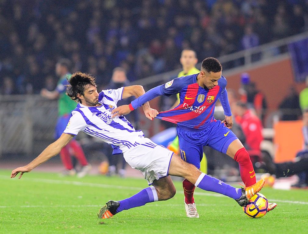 Real Sociedad's defender Carlos Martinez (L) vies with Barcelona's Brazilian forward Neymar da Silva Santos Junior during the Spanish league football match Real Sociedad vs FC Barcelona at the Anoeta stadium in San Sebastian, on November 27, 2016. / AFP /