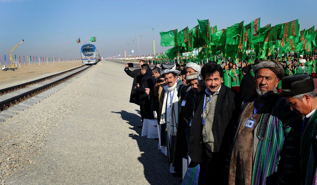Officials and Turkmen traditional dancers gather at Turkmenistan's Imamnazar customs point on November 28, 2016 as they watch a freight train heading to Afghanistan's Akina during a ceremony marking the opening of the first section of a $2 billion railway