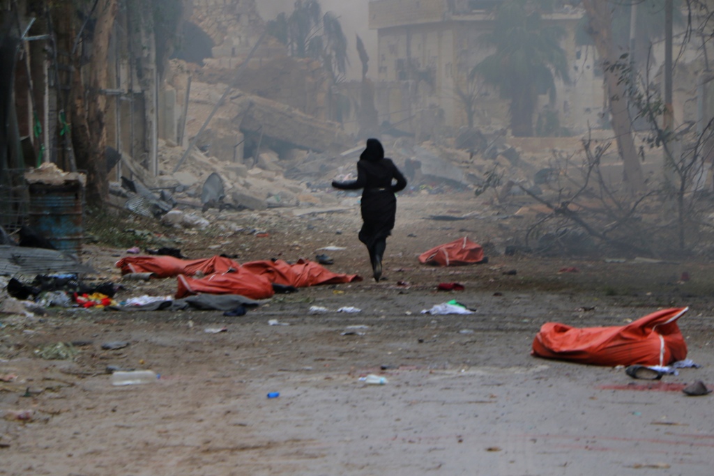 Image depicts death] A teenage girl runs among the dead bodies on the ground at the site of blast after Assad Regime's strike over civilians in residential areas of Jib Al-Quebeh neighborhood of Aleppo, Syria on November 30, 2016. Ibrahim Ebu Leys - Anado