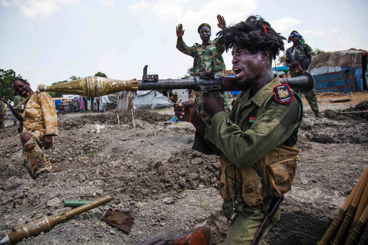 soldiers of the Sudan People Liberation Army (SPLA) celebrate while standing in trenches in Lelo, outside Malakal, northern South Sudan, on October 16, 2016. Heavy fighting broke out on Ocotober 14 between SPLA (Government) and opposition forces in Wajwok