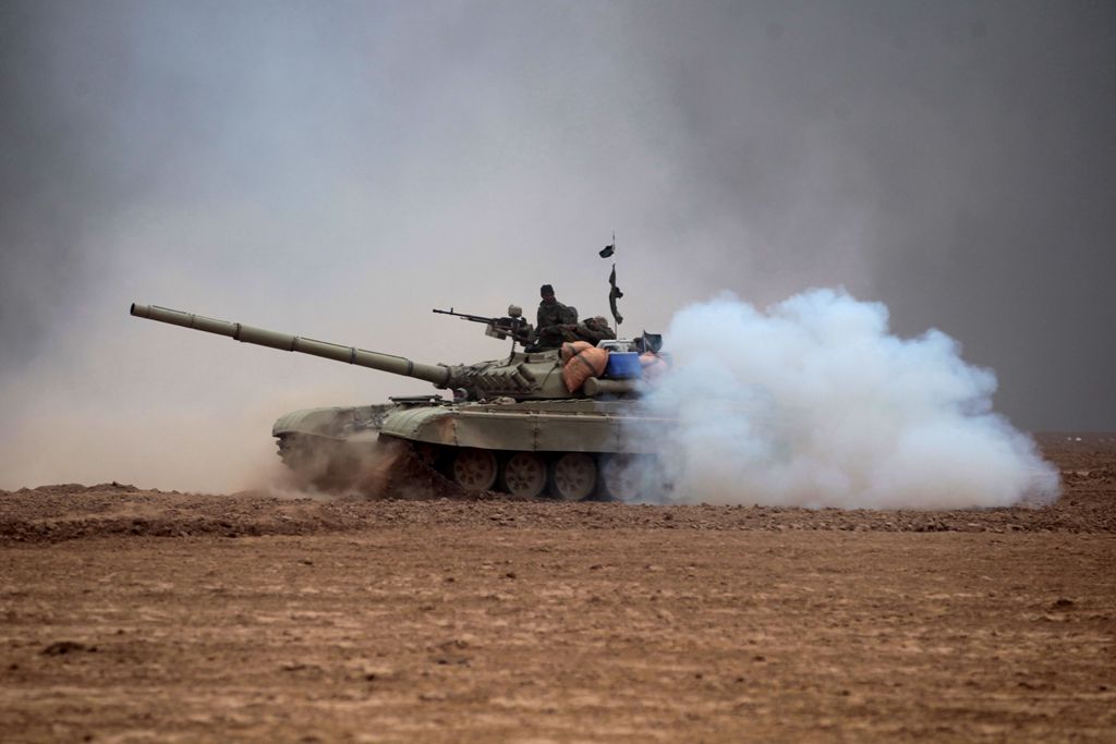 Iraqi Shiite fighters from the Hashed al-Shaabi (Popular Mobilisation) paramilitaries manoeuver a T-72 tank as they advance near the village of Tal Abtah, south of Tal Afar, on November 30, 2016, during a broad offencive by Iraq forces to retake the city 