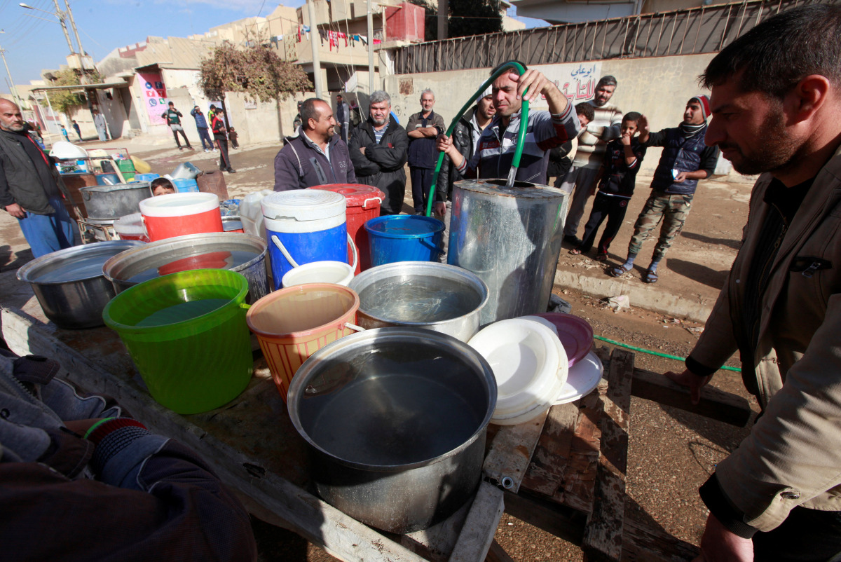 Iraqi people collect water in Mosul, Iraq, December 3, 2016. REUTERS/Alaa Al-Marjani