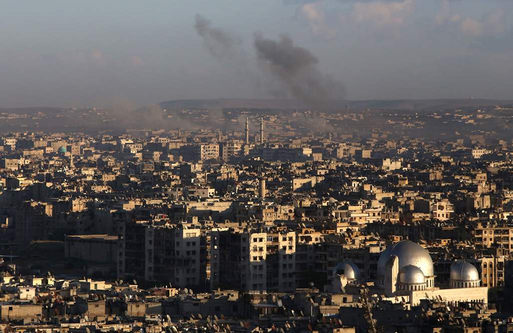A general view taken from the government-held side of Aleppo shows smoke billowing during fighting between Syrian regime forces and rebel fighters in east Aleppo, on December 3, 2016. AFP / Youssef KARWASHAN
