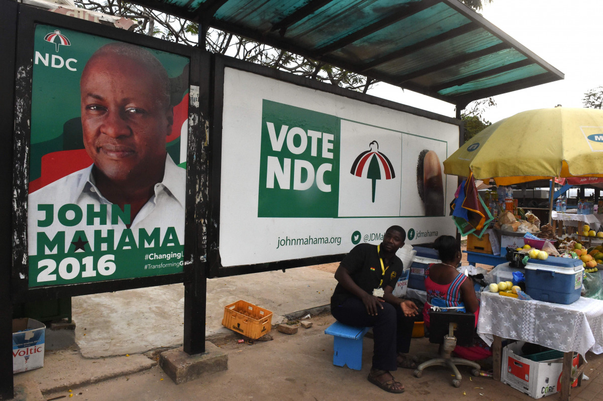 Street vendors sell wares in Accra, on December 2, 2016, next to an electoral poster of President John Mahama, who is the candidate of the ruling Democratic Congress (NDC) ahead of the December 7 presidential elections. AFP / Pius Utomi EKPEI