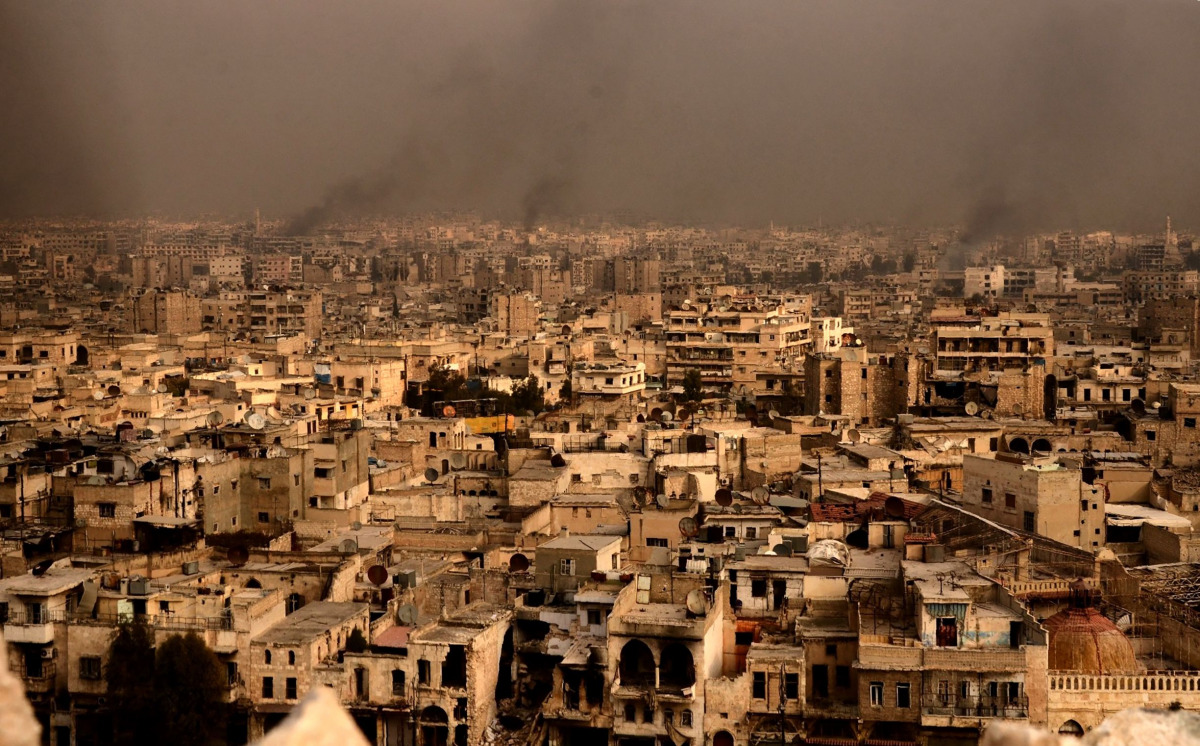 A general view taken from Aleppo's citadel show fumes rising following shelling on neighbourhoods in the old city on December 7, 2016. AFP / GEORGE OURFALIAN