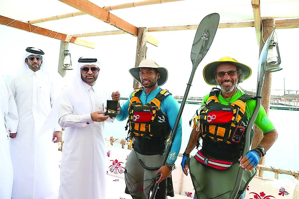 Katara General Manager Dr Khalid bin Ibrahim Al Sulaiti presents a memento to Kuwaiti kayakers Bashar Al Huneidi and Mansoor Al Safran.