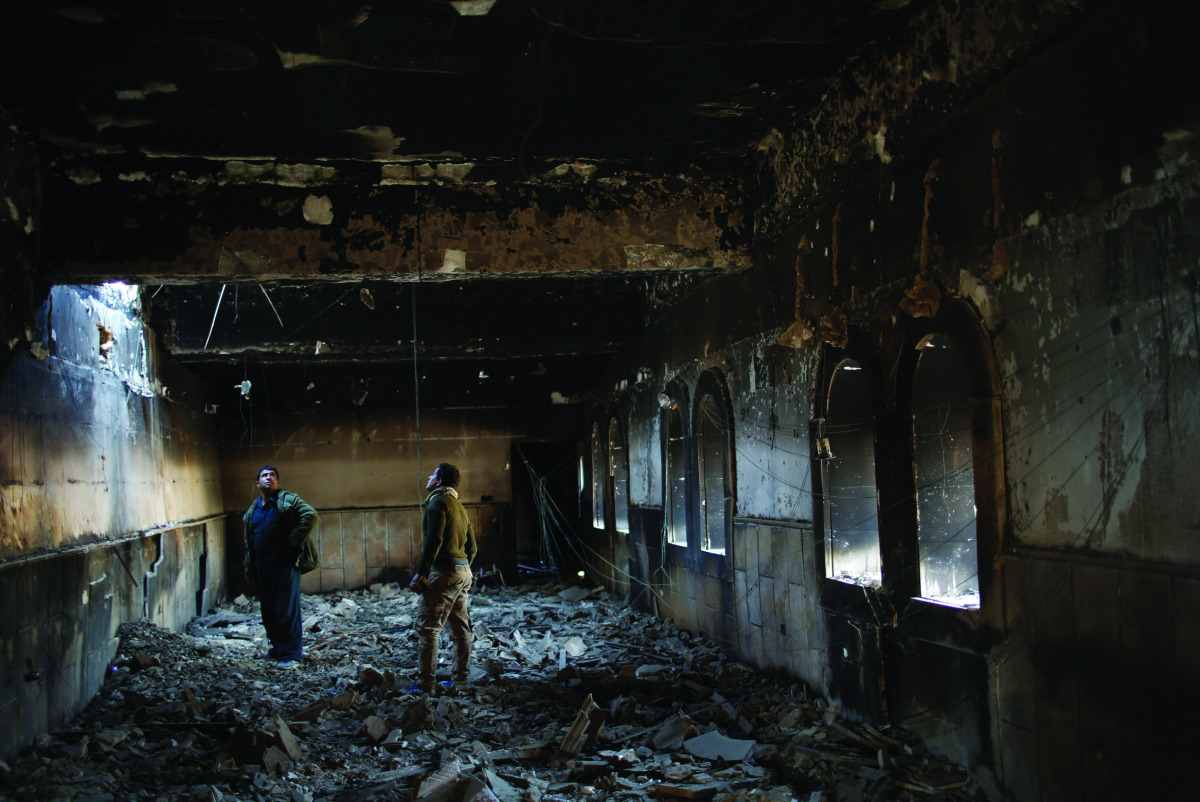 Iraqi soldiers look at a heavily damaged building after recaptured it from Islamic State militants in Qaraqosh, near Mosul, yesterday. 