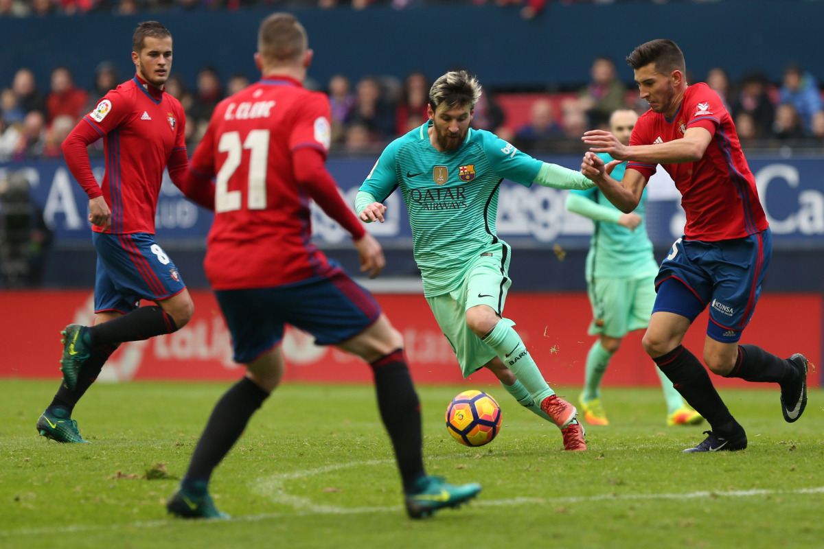Barcelona's Argentinian forward Lionel Messi (C) vies with Osasuna's defender David Garcia during the Spanish league football match CA Osasuna vs FC Barcelona at the Reyno de Navarra (El Sadar) stadium in Pamplona on December 10, 2016. (AFP / Cesat Manso)