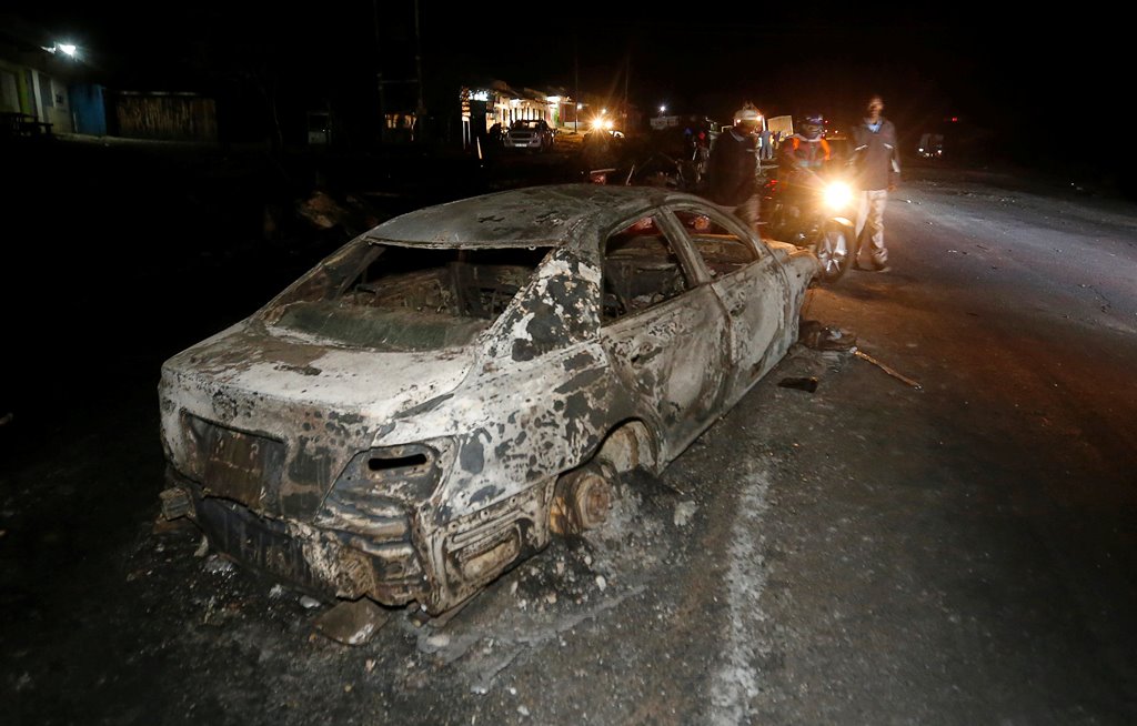 People look at the wreckage of a car burnt after a fireball from an tanker engulfed several vehicles and killed several people, near the Rift Valley town of Naivasha, west of Kenya's capital Nairobi, December 11, 2016. REUTERS/Thomas Mukoya