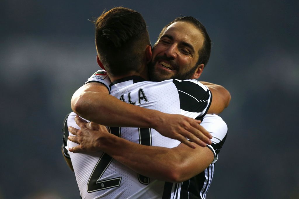 Juventus' Argentinan forward Gonzalo Higuain (R) jubilates with Juventus' Argentinan forward Paulo Dybala at the end of the Italian Serie A football match between Torino and Juventus on December 11, 2016 at the 'Grande Torino Stadium' in Turin. / AFP / MA