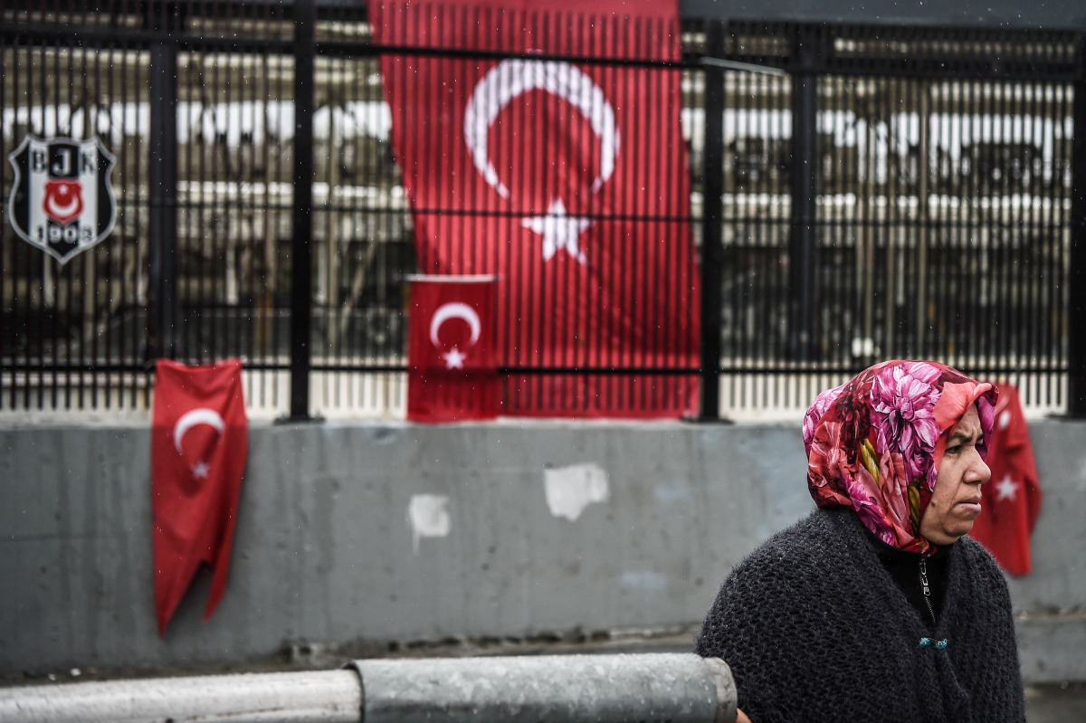 A woman stands in front of Turkish national flags that are displayed at the site of the December 10 blasts outside Besiktas' Vodafone Arena football stadium on December 13, 2016 in Istanbul.
Twin blasts hit Istanbul on December 10, 2016 killing 37 police
