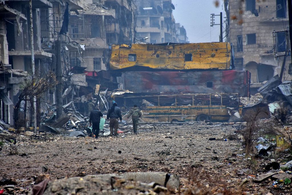 Syrian pro-government forces walk in Aleppo's Bustan al-Qasr neighbourhood after they captured the area in the eastern part of the war torn city on December 13, 2016.  AFP / George OURFALIAN
