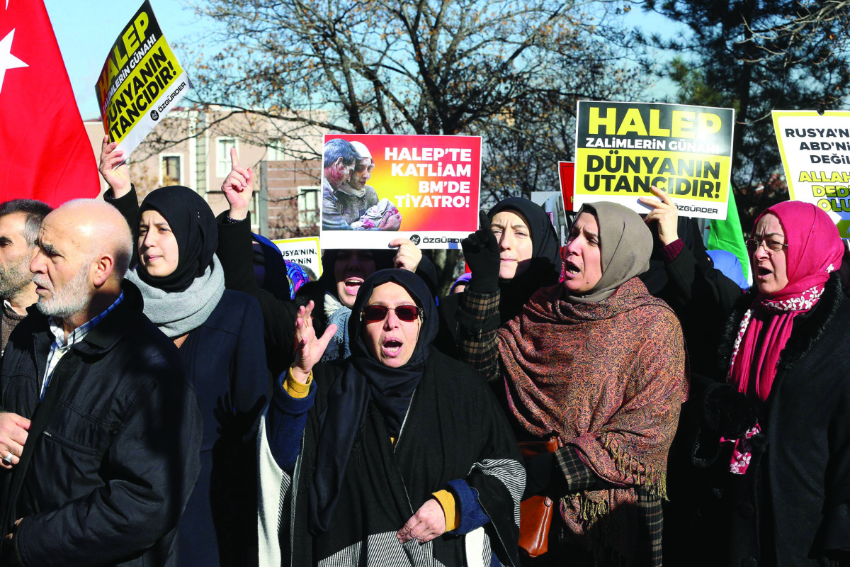 Protesters hold placards reading 