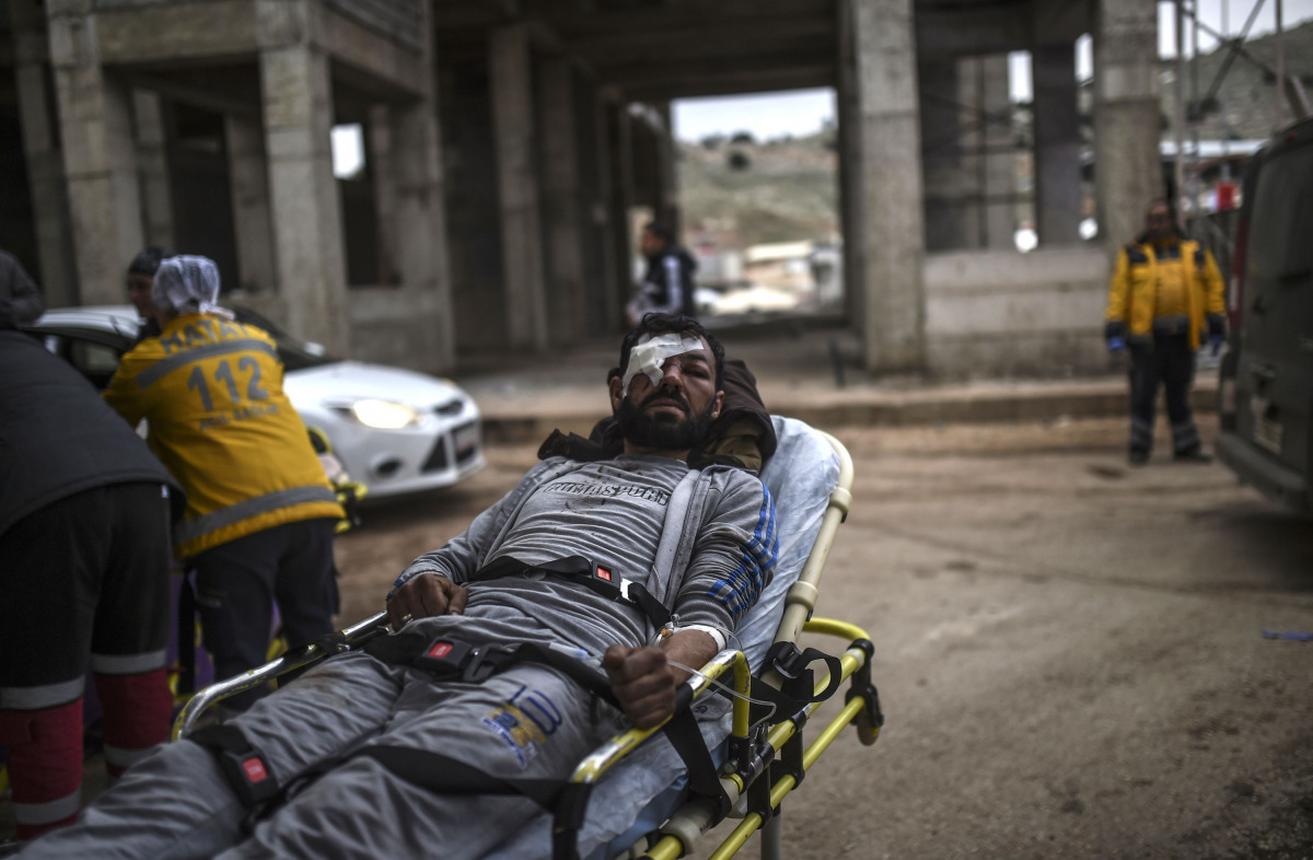 n injured Syrian man from Aleppo waits on a stretcher as he is being transported from the Syrian side of the Bab al-Hawa border crossing to a hospital in Turkey on December 16, 2016. The Syrian government suspended the evacuation of the last rebel-held pa