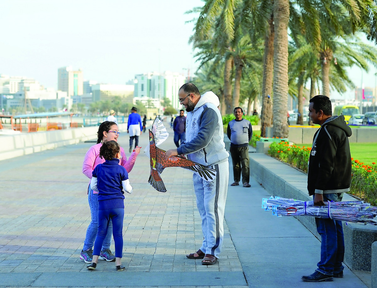Children looking at a bird-shaped kite on the Corniche yesterday bought from a vendor. Pic: Salim Matramkot / The Peninsula