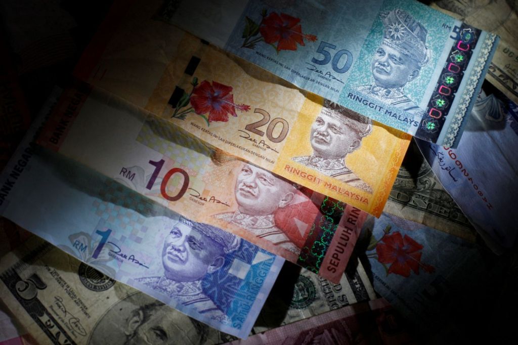 Malaysia's ringgit touched the lowest level since the Asian financial crisis as investors continue to sell down emerging-market assets and after a crackdown on currency speculators last month exacerbated outflows. PHOTO: REUTERS.