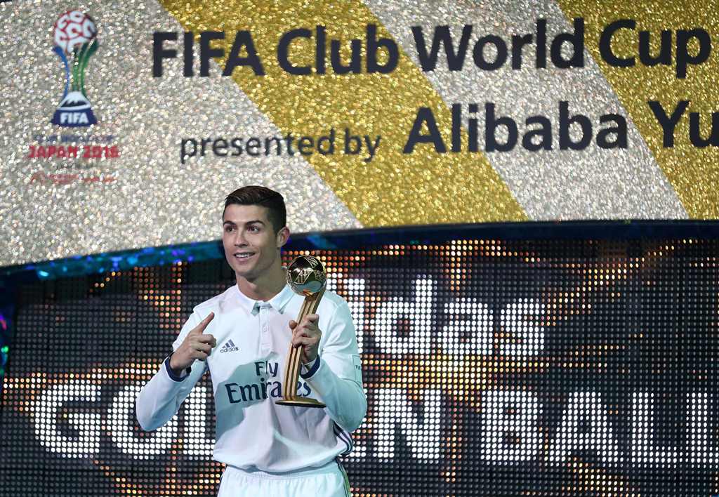 Real Madrid's forward Cristiano Ronaldo poses as he holds the Golden Ball trophy after winning the Club World Cup football final match between Kashima Antlers of Japan and Real Madrid of Spain at Yokohama International stadium in Yokohama on December 18, 