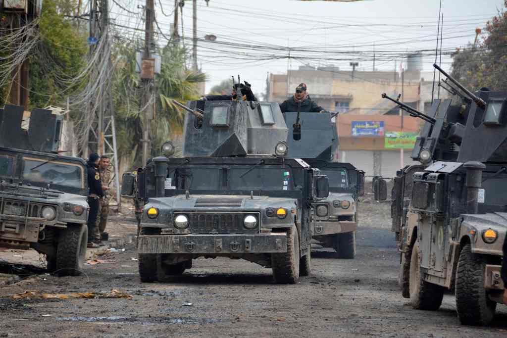 Iraqi special forces gather next to their armoured vehicles in the neighbourhood of al-Barid, east of Mosul, on December 18, 2016 during their ongoing operation against Islamic State (IS) group jihadists to wrest back the city. / AFP / Mahmoud AL-SAMARRAI