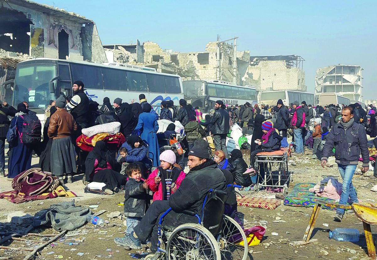 Syrians wait to be evacuated from the eastern part of Aleppo, that had been under siege by regime forces and its supporters, at a crossing point in Amiriyah district of Aleppo, yesterday.