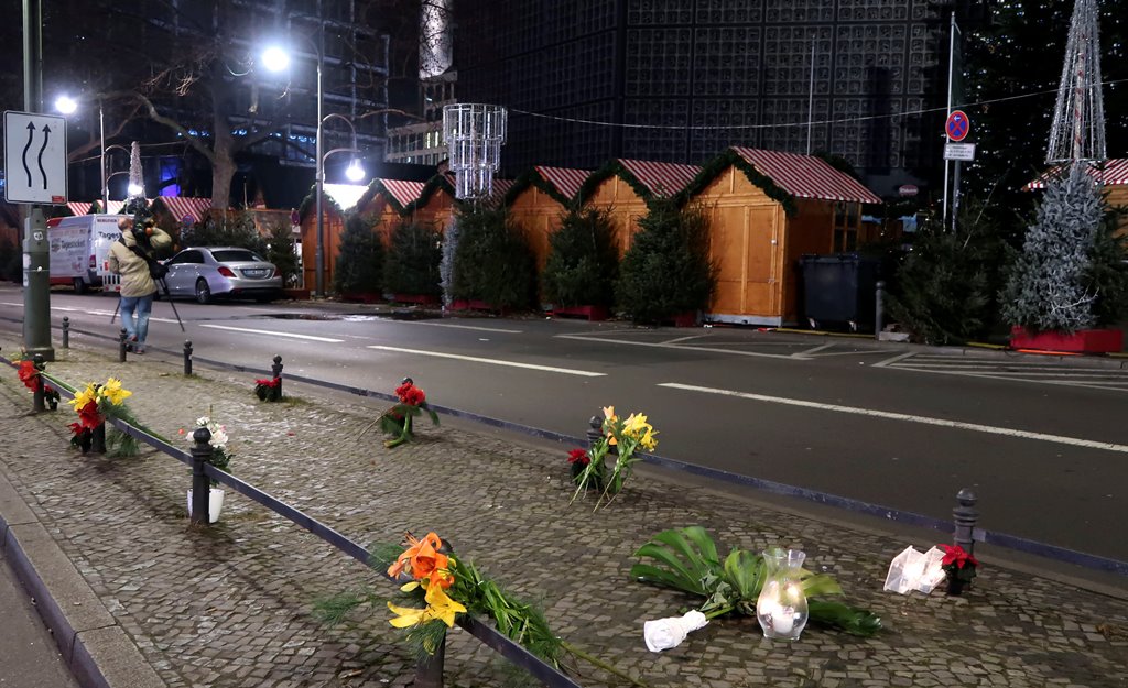 Candles and flowers are seen near the site where a truck ploughed through a crowd at a Berlin Christmas market on Breitscheidplatz square near the fashionable Kurfuerstendamm avenue in the west of Berlin, Germany, December 20, 2016. Reuters/Fabrizio Bensc