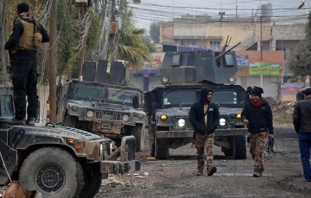 Iraqi special forces gather next to their armoured vehicles in the neighbourhood of al-Barid, east of Mosul, on December 18, 2016 during their ongoing operation against Islamic State (IS) group jihadists to wrest back the city. / AFP / Mahmoud AL-SAMARRAI
