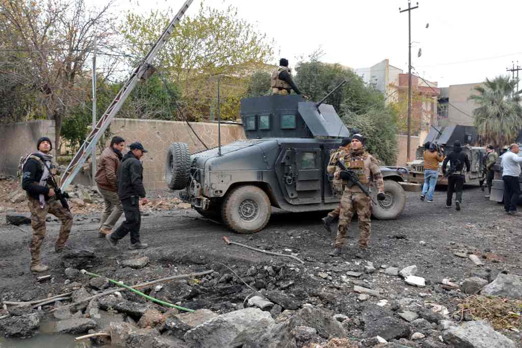 Iraqi special forces gather next to their armoured vehicles in the neighbourhood of al-Barid, east of Mosul, on December 18, 2016 during their ongoing operation against Islamic State (IS) group jihadists to wrest back the city. / AFP / Mahmoud AL-SAMARRAI