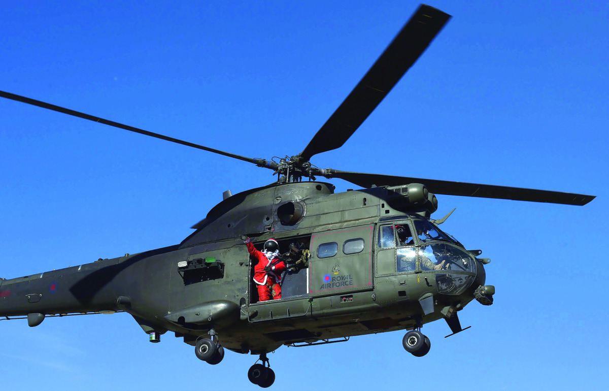 A soldier from Resolute Support (RS) troops dressed as Santa Claus, waves from a military helicopter during a football match to commemorate the Christmas Truce of 1914 at the ISAF Headquarters, in Kabul, Afghanistan December 25, 2016. REUTERS/Omar Sobhani